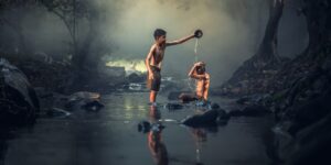 Dua orang anak mandi di sungai