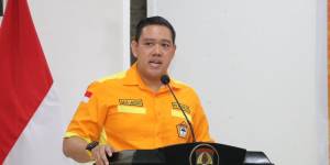 Anggota Komisi I dari Partai Golkra Dave Laksono berpidato di mimbar dengan baju berwarna oranye, seragam ormas Kosgoro 57