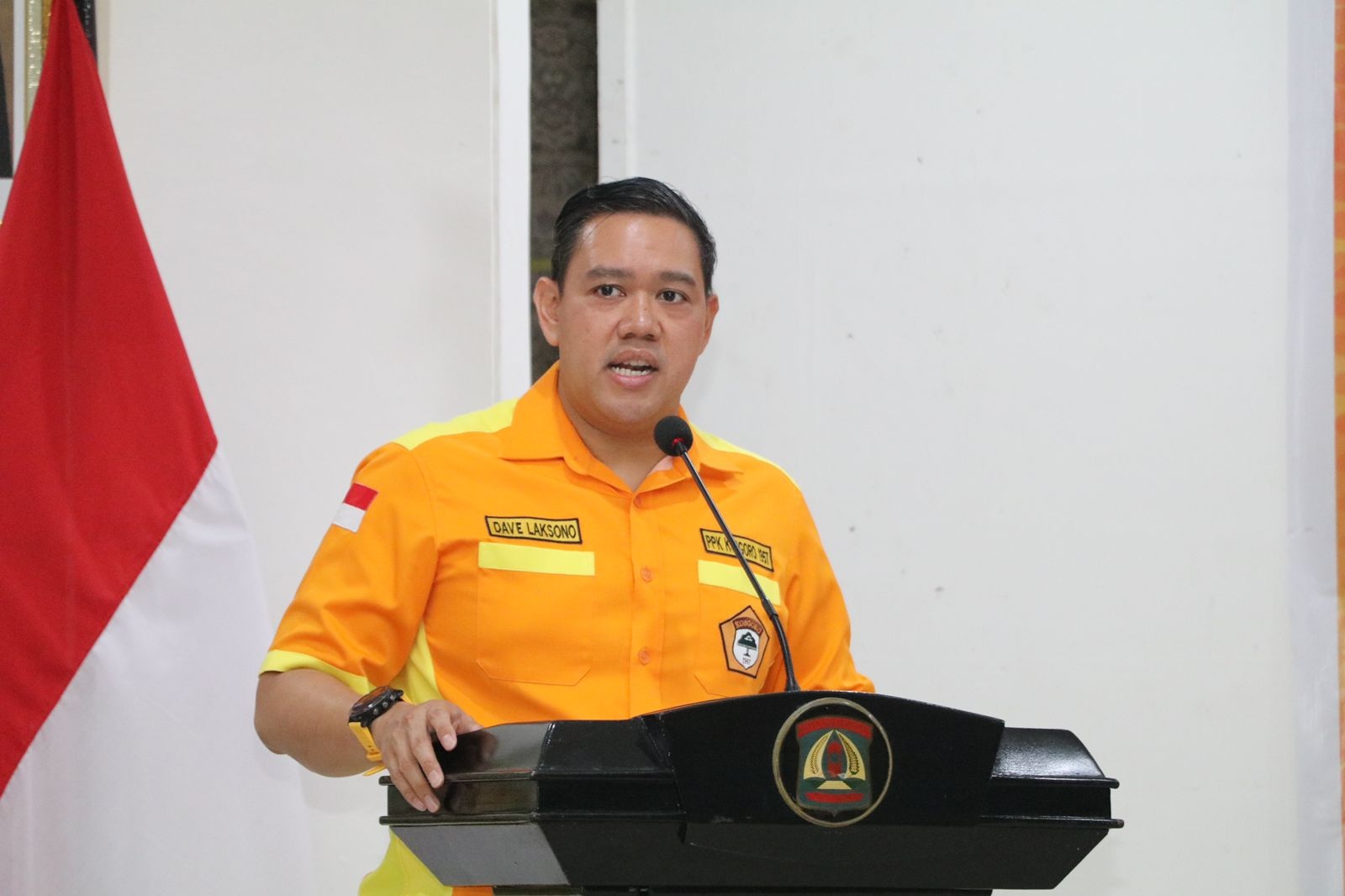 Anggota Komisi I dari Partai Golkra Dave Laksono berpidato di mimbar dengan baju berwarna oranye, seragam ormas Kosgoro 57