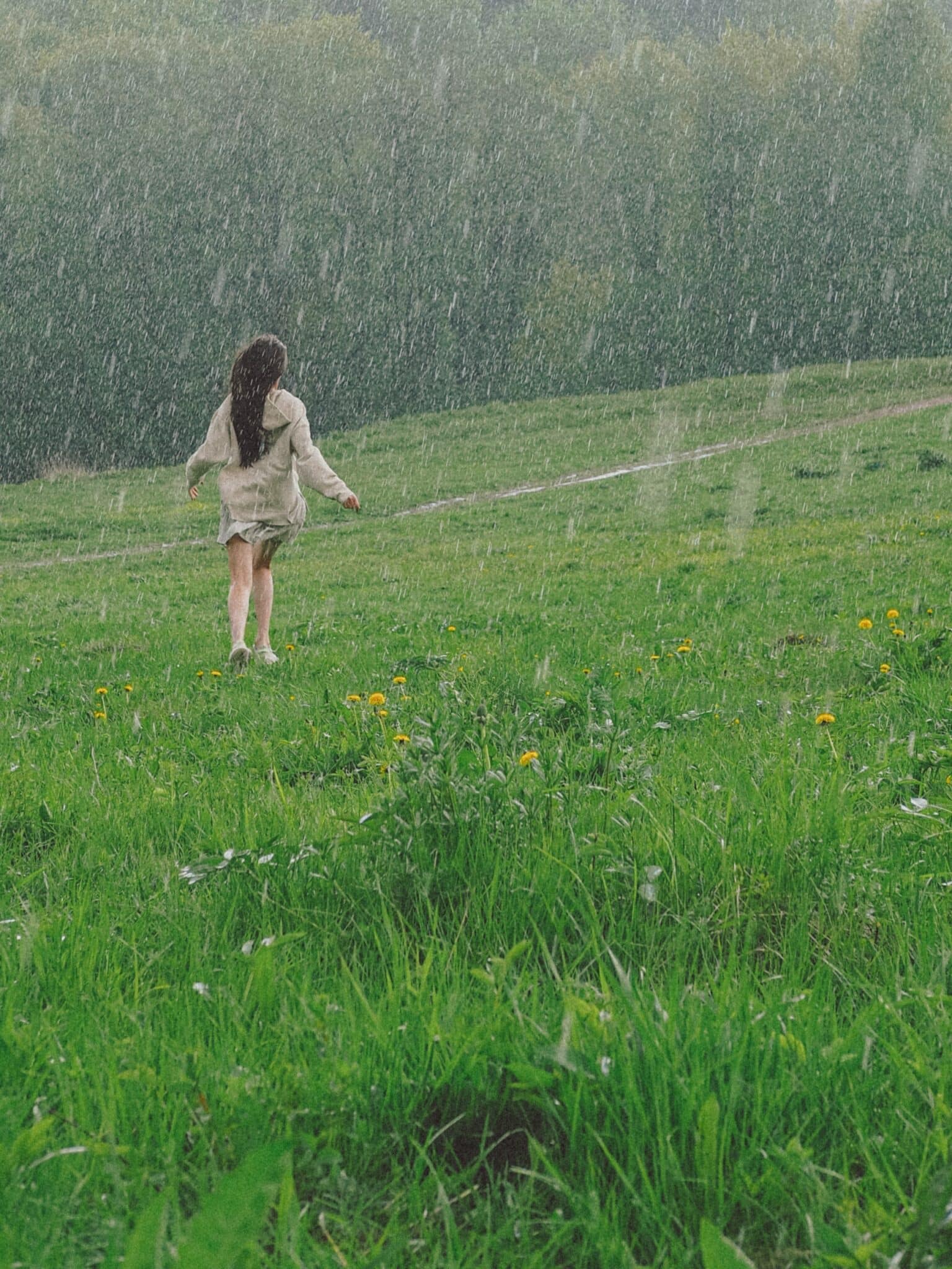 Ilustrasi hujan. Photo by Viktorya  Sergeeva 🫂: https://www.pexels.com/photo/woman-enjoying-the-rain-outside-a-grass-field-8676395/
