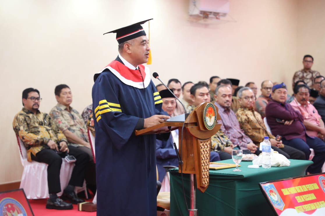 Ahmed Zaki Iskandar menggunakan toga wisuda mempertahankan disertasi di IPDN